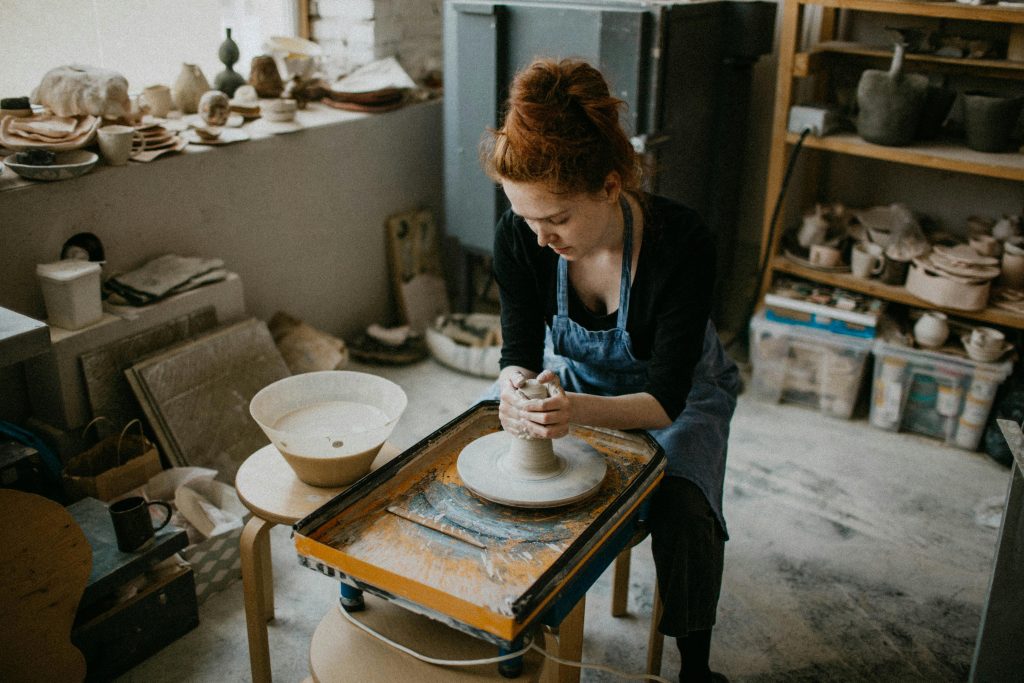 Woman using a pottery wheel in an art studio